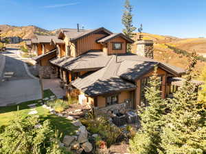 View of front facade with board and batten siding, stone siding, a mountain view, and roof with shingles