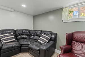 Carpeted cinema with baseboards and an AC wall unit