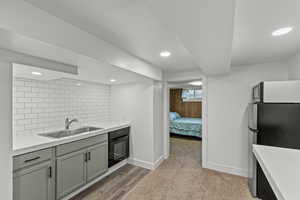 Kitchen with freestanding refrigerator, recessed lighting, oven, tasteful backsplash, and light wood-type flooring