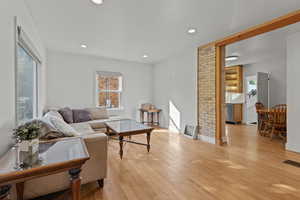 Living area featuring light wood-type flooring, plenty of natural light, and recessed lighting