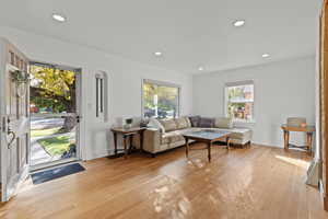 Living room with light wood-style floors and recessed lighting