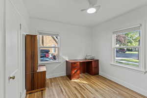 Unfurnished office featuring light wood-style flooring and a ceiling fan