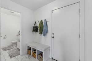 Mudroom featuring tile floors, a bench with custom cushion and storage