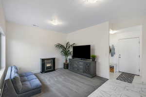 Living room or optional office space with carpet, tile flooring and modern light fixtures