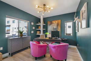 Home office with a chandelier and wood finished floors.  This office has a full closet and can be a 4th bedroom.