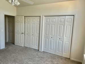 Unfurnished bedroom featuring two closets, carpet, and a ceiling fan