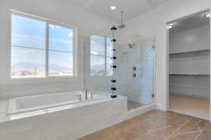 Bathroom featuring a mountain view, a garden tub, a spacious closet, a shower stall, and tile patterned flooring