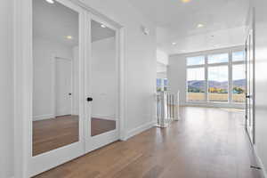 Hallway with recessed lighting, wood finished floors, an upstairs landing, a mountain view, and french doors