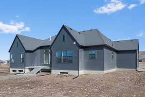 Back of property with a shingled roof
