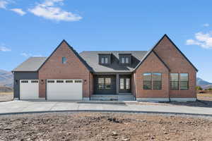 View of front of house featuring a porch, a mountain view, driveway, and brick siding