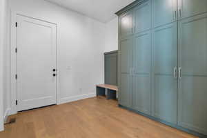 Mudroom with light wood finished floors and baseboards