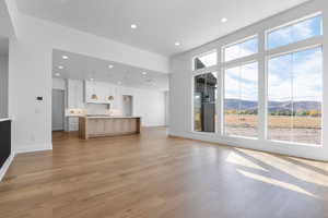 Unfurnished living room featuring a mountain view, recessed lighting, and light wood-type flooring
