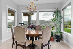 Dining space featuring a mountain view, light tile patterned floors, and a chandelier
