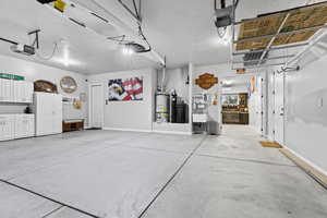 Garage featuring strapped water heater and a garage door opener
