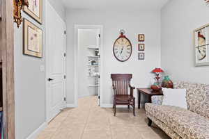 Living area featuring light tile patterned flooring and baseboards