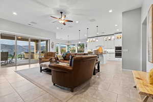 Living room with a mountain view, recessed lighting, a ceiling fan, and light tile patterned floors