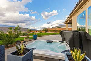 View of swimming pool featuring an outdoor hot tub, a patio area, a mountain view, and grilling area