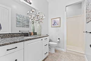 Full bath featuring vanity, light tile patterned flooring, and a shower stall