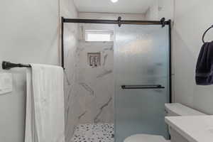 Bathroom with a marble finish shower and vanity