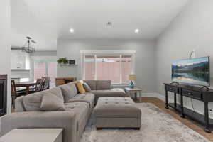 Living area featuring wood finished floors, recessed lighting, and a chandelier