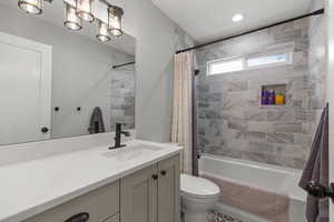 Bathroom with shower / tub combo with curtain, vanity, and a chandelier