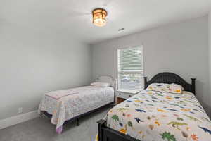 Bedroom featuring carpet and a textured ceiling
