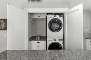 Laundry room with stacked washing machine and dryer