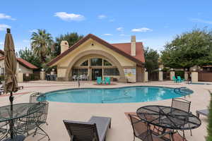 Community pool with a patio area and outdoor dining area