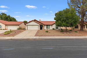 View of front of home featuring a tile roof, stucco siding, concrete driveway, and a garage