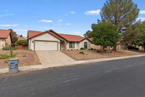 View of front of property with a tiled roof, stucco siding, an attached garage, and concrete driveway