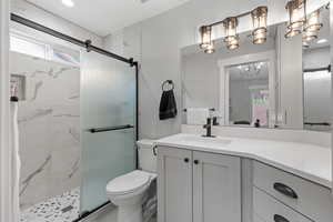 Full bathroom with a stall shower, vanity, and recessed lighting