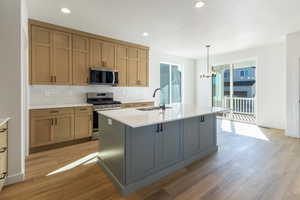 Kitchen featuring decorative backsplash, stainless steel appliances, light stone counters, decorative light fixtures, and a chandelier
