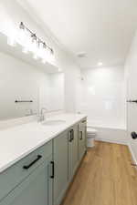 Full bathroom featuring vanity, washtub / shower combination, and light wood finished floors