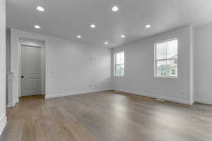 Empty room featuring recessed lighting, light wood-style floors, and a textured ceiling