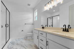 Full bathroom with double vanity and a stall shower