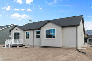 Back of house featuring stucco siding, roof with shingles, and a mountain view