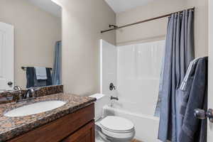 Bathroom featuring shower / bath combination with curtain and vanity