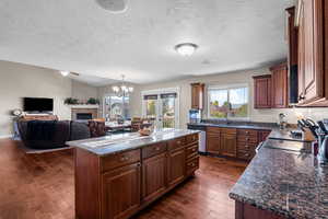 Kitchen with a center island, dark wood-style floors, a chandelier, dishwasher, and open floor plan