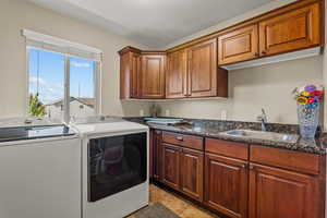 Laundry area with cabinet space, separate washer and dryer, and light tile patterned flooring