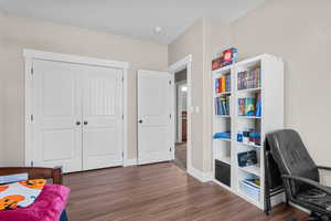 Bedroom featuring dark wood finished floors and baseboards