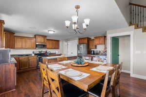Dining space with dark wood-type flooring, arched walkways, and a chandelier