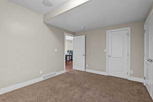 Unfurnished bedroom featuring baseboards and carpet