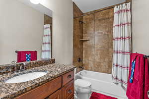 Full bath with shower / bath combo with shower curtain and vanity