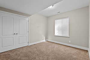 Unfurnished bedroom featuring carpet floors and a closet