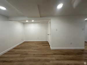 Finished below grade area with a textured ceiling, recessed lighting, and dark wood-type flooring