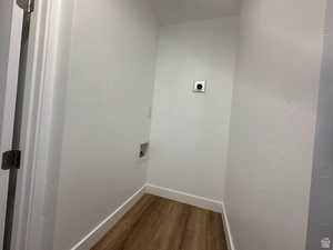 Laundry area with dark wood finished floors, hookup for an electric dryer, and hookup for a washing machine