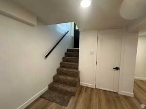 Staircase featuring wood finished floors