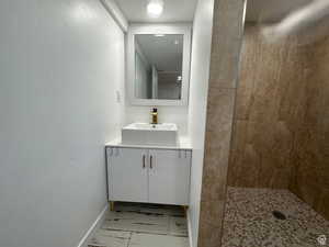 Bathroom featuring vanity, a stall shower, and a textured wall