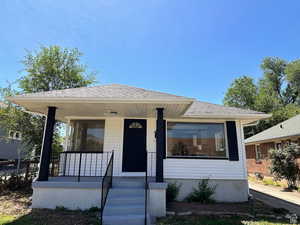 View of front of home with a shingled roof and a porch