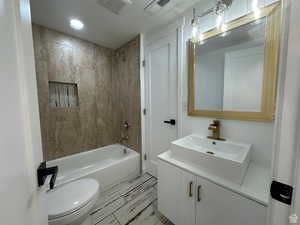 Full bath with vanity, tub / shower combination, a textured ceiling, and recessed lighting